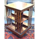 A late 19th century boxwood and ebony chequer edged red walnut revolving bookcase comprising eight