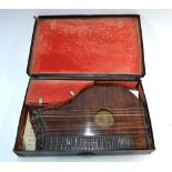 A system Tuzzi Zither with flame mahogany face, retailed by F.