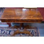 A Victorian rosewood card table, the fold over rotating top over a storage well,