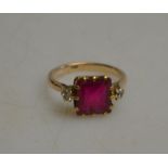 A square synthetic ruby ring having a small diamond on either side,