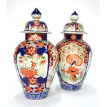 A pair of Japanese Imari baluster vases and covers; each one decorated with a Yamato Nadeshko,