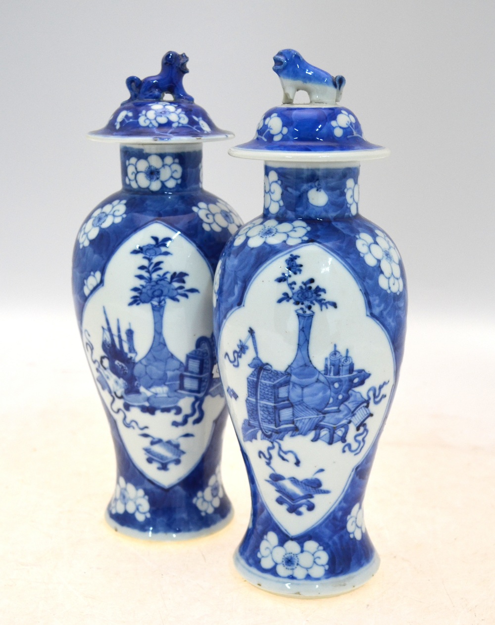 A pair of blue and white vases and covers; 26 cm high; each base with a Kangxi four-character mark,