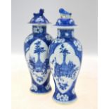 A pair of blue and white vases and covers; 26 cm high; each base with a Kangxi four-character mark,