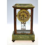 A late 19th century onyx mounted lacquered brass four window mantel clock,