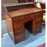 A 19th century mahogany galleried top kneehole chest of two short over six pedestal drawers raised