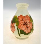 A Moorcroft vase decorated with the Hibiscus pattern on a cream ground,
