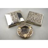 Two Siamese Sterling cigarette boxes with embossed and chased tops,