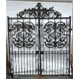 A substantial pair of Georgian style wrought iron linear and scroll panel decorated entrance gates,