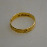 An 18ct scroll engraved wedding band, approx 2g,