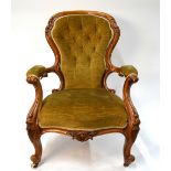 A Victorian walnut framed button upholstered spoon back open armchair raised on moulded cabriole