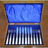 An oak-cased set of electroplated fish knives and forks with mother of pearl handles (little used)
