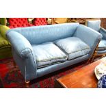 A blue satin upholstered sofa raised on turned giltwood fluted front legs to brass castors,