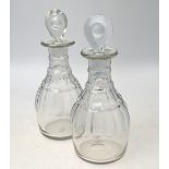 A pair of Georgian cut glass barrel shaped decanters with three facetted rings and lozenge shaped