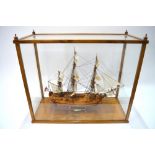 A well-detailed model of HMS Bounty (1787), under sail, in glazed case, 20th century,