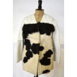 A black and white pony fur jacket with white leather shoulders and sleeves, purple satin lining,