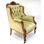 A late 19th century moulded mahogany framed button upholstered armchair with shaped wing back and