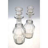 A pair of glass decanters and stoppers; each decanter with trumpet neck and oviform, faceted body,