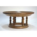 An Asian carved teak bowl, raised on turned pillars and ring base,