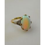 Oval opal cabochon ring in yellow gold setting with white gold shoulders, stamped 18ct,