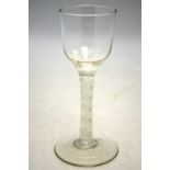 A Georgian wine glass having an ogee bowl, multiple opaque twist stem, domed foot and rough pontil,