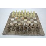 A serpentine marble and onyx chessboard with chess-men,