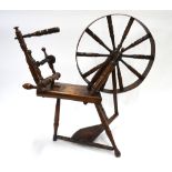 A 19th century elm and fruitwood spinning wheel stamped M.