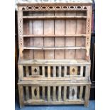 A 19th century Irish stripped pine dresser in two parts having pierced decoration and four 'hatch'