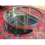 A Bond circular polished steel framed coffee table with inset glass top and heavy tinted glass base