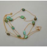 Yellow gold trace style guard chain having turquoise beads spaced throughout,