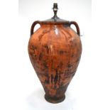 An antique terracotta olive jar mounted as a large table lamp,