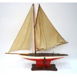 An Edwardian painted wood pond yacht with linen sails and weighted keel, on stand,