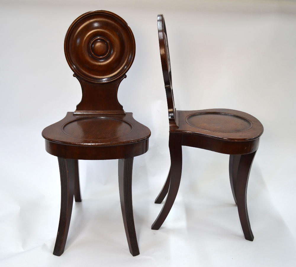 A pair of late Georgian mahogany hall ch