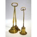 Two solid-cast brass door stops with loop handles,