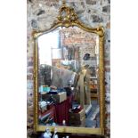 A giltwood and gesso late 19th/20th century rococo style mirror with bevelled arched plate