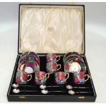 A set of six porcelain lustre coffee cans and saucers to/w six silver bean end coffee spoons,