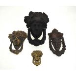 A Victorian cast iron Bacchanialian mask door knocker and three brass examples (4)