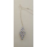 A marquise shaped pendant set with nine tanzanites,