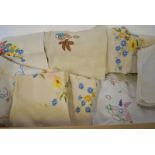 Two boxes containing a collection of floral embroidered tablecloths,