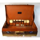 A good quality pig-skin suitcase with fittings including; five silver and ivory-mounted jars,