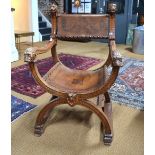 A carved walnut framed Glastonbury chair with lion head terminals and arm ends,