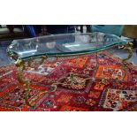 An shaped brass coffee table with inset heavy plate glass top,