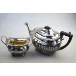 An oblong silver half-reeded teapot on cast claw feet, George Nathan & Ridley Hayes, Chester 1910,