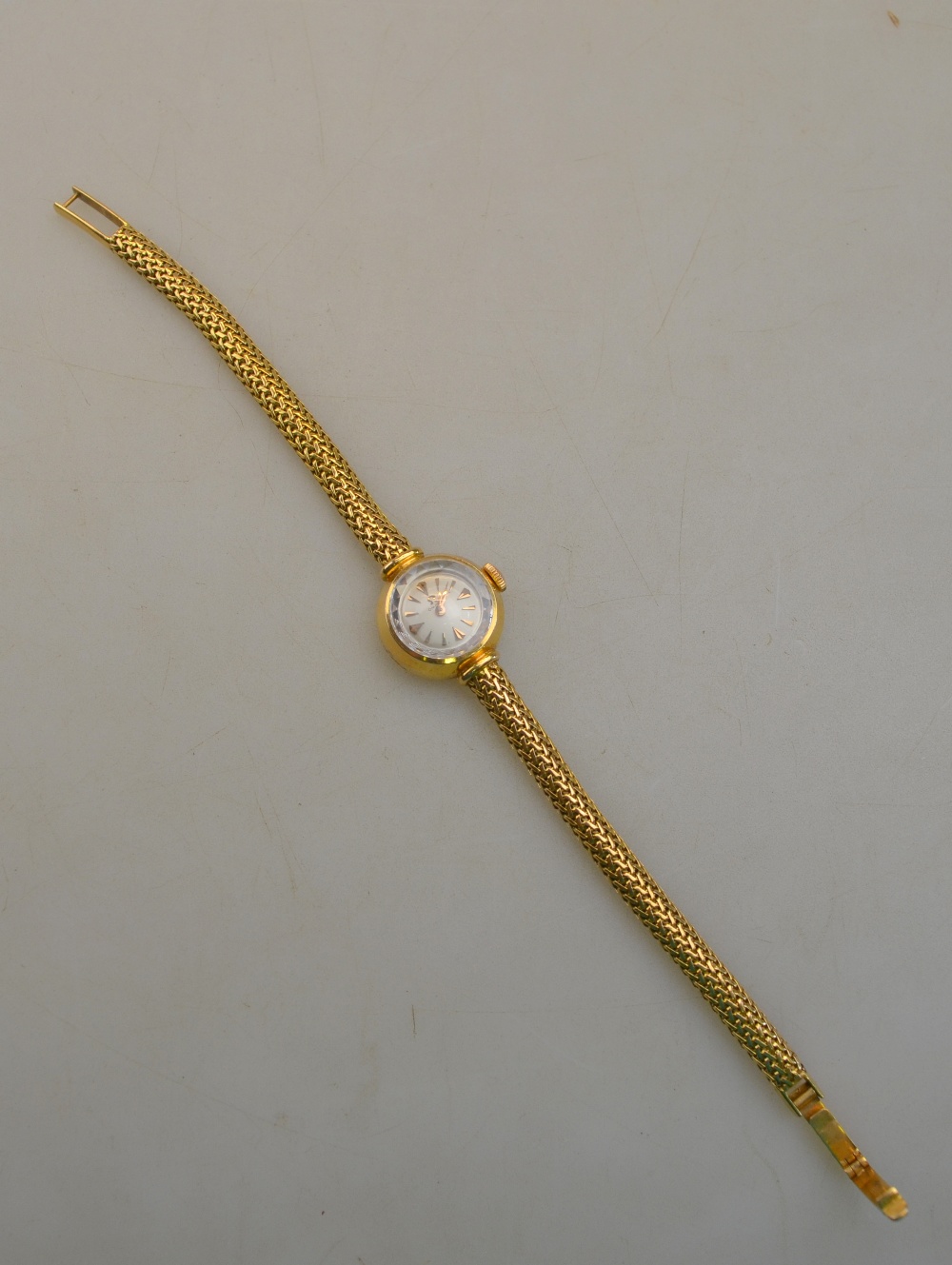 A lady's 18k Omega wristwatch with 1 cm silvered dial on flexible mesh snake bracelet, 24.