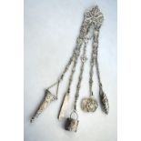 A Victorian silver chatelaine with chased and pierced buckle and fancy-link chains hung with a