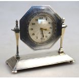 An engine-turned silver desk clock, the textured silvered dial in octagonal frame,