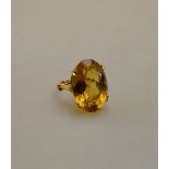 A single stone ring with oval citrine, yellow metal set in four double claw setting,