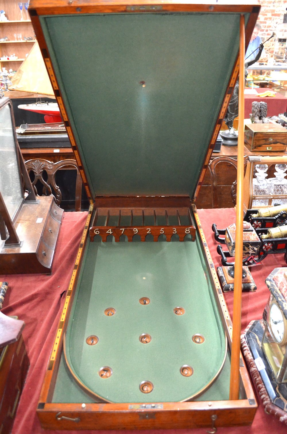 An antique mahogany cased folding bagatelle board, the interior baize lined and complete with balls,