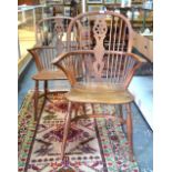 A pair of early 19th century yew wood and elm Windsor elbow chairs,