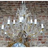 A glass ten-branch electrolier with fifteen sconces, hung with facetted bead garlands,