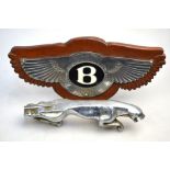 A chromed enamel Bentley badge on wooden plaque, 20 cm to/w a chrome Jaguar car mascot,